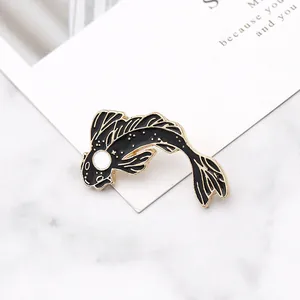 Macro view of black koi fish enamel brooch with gold trim and glitter starry details