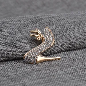 Detailed close-up of high heel brooch with sparkling rhinestones and gold alloy finish