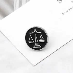 Detailed close-up of a Libra zodiac enamel pin badge featuring a silver scales design