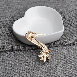 Detailed back view of golden high heel brooch showing pin clasp and metal texture