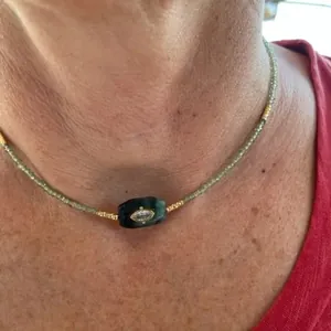 Detail der Perlenkette mit grünem Steinanhänger und Zirkon-Teufelsauge für Damen
