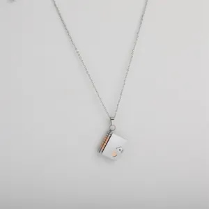 Silver book-shaped locket necklace with rose gold heart detail and secure clasp