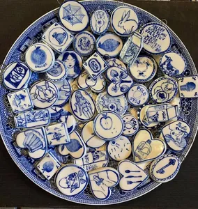 Vue macro de pendentifs en céramique bleue et blanche avec divers motifs et or 18 carats