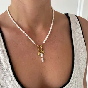 Detail van parelketting met gouden schelphanger en veersluiting gedragen door een model