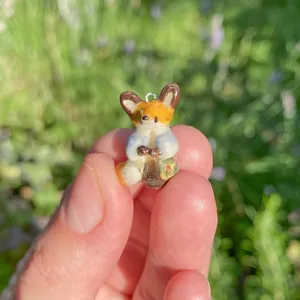 Miniature fox animal pendant in 18K gold plated stainless steel shown held by fingers