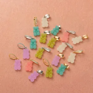 Ciondoli a forma di orsetto macaron colorati con fibbie in pietra lucida su sfondo arancione
