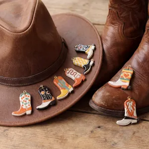 Set of seven retro western cowboy boot pendants with golden rings on leather background