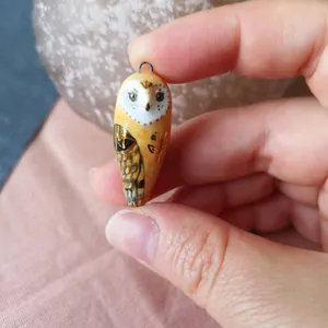 Macro shot of 14K gold plated owl pendant with detailed hand-painted ceramic texture