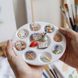 Parure de bijoux thème atelier d'art avec breloques palette et chevalet sur plateau