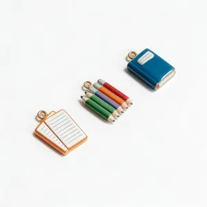 Macro view of stationery pendants including mini books and colored pencil set charms