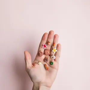 Detailed view of various mini resin food charms like donuts and stars on a hand palm