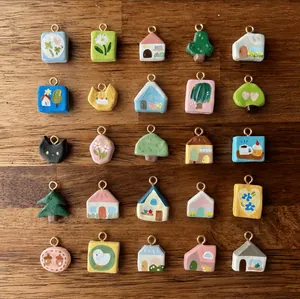 25-piece colorful handmade clay pendants with 18K gold loops on a wooden surface