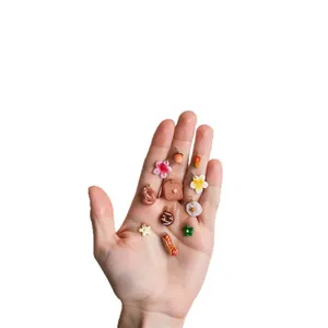 Mini food pendants set with 18k gold plating shown on hand for size perspective
