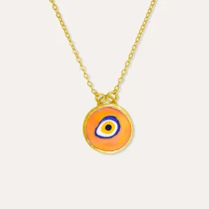 Macro detail of 18k gold plated evil eye pendant with vibrant orange enamel inlay