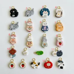 Detailed view of 12 cute animal pendants including cats and strawberries for DIY jewelry