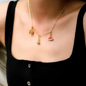 Détail d'un collier doré avec pendentifs de raisin en zircon et pastèque en émail sur modèle