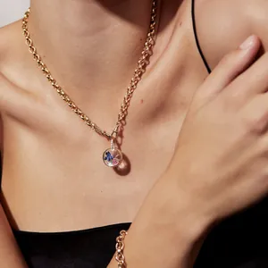 Retro 18k gold glass locket necklace with colorful floral gemstones on a model