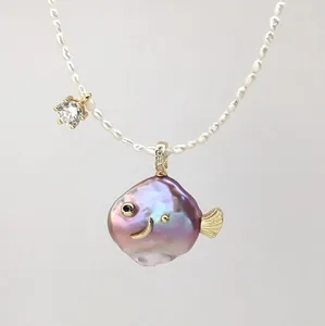 Detail of a fish-shaped purple baroque pearl pendant on a white freshwater pearl necklace