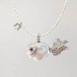 Macro shot of baroque pearl goldfish pendant with silver fin and zircon detail