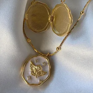 Vintage gouden engel medaillon ketting met wit emaille op een zachte witte zijden basis