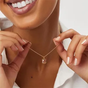 Détail du collier pendentif vert olive carré avec chaîne en or porté au cou