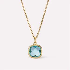 Vue macro d'un collier pendentif carré bleu clair serti sur une chaîne dorée