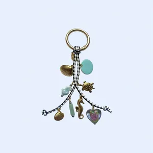 Détail d'un porte-clés marin coloré avec breloques de coquillage, tortue et hippocampe