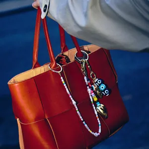 Handwoven oversized leather tote with evil eye bead charm and gold heart keychain