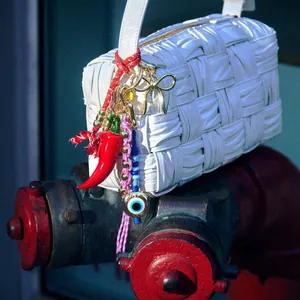 White woven leather handbag with colorful evil eye beads and red pepper charms