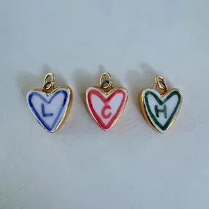 Gros plan de pendentifs en forme de cœur avec bords dorés en rouge, bleu et vert