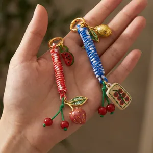 Handmade woven cord keychain with strawberry watermelon and mahjong charm pendants