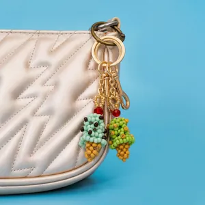 Handgefertigte Perlen-Eiscreme-Anhänger mit goldenem Verschluss an einer Handtasche