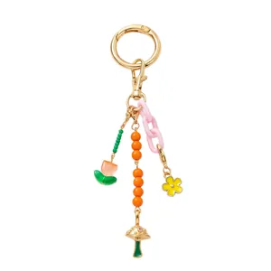 Detail of DIY keychain with gold metal ring, tulip pendant, and colorful bead charms