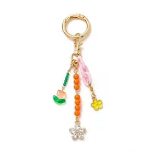 Detail of 18K gold-plated keychain with orange floral crystals and colorful pendants