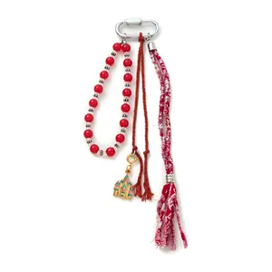 Porte-clés à perles rouges avec gland floral et breloque château dorée sur fond blanc