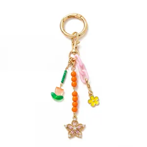 Detail of colorful beaded keychain with gold star charm and tulip pendants on white background