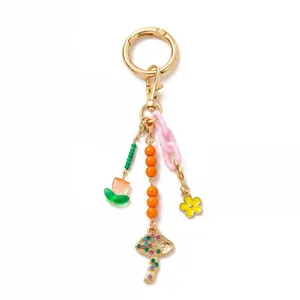 Detail of colorful DIY keychain with tulip and mushroom pendants in gold plating