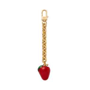 Detailweergave van een gouden aardbeien hanger met een MC gegraveerde karabijnsluiting