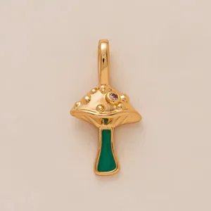 Detailed view of mushroom charm with gold finish, purple stone, and green enamel stem
