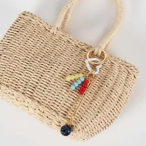 Bohemian 18K gold-plated keychain with colorful beads and heart charm on a straw bag