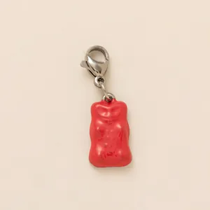 Vista macro de un colgante de oso rojo con cierre de langosta plateado para accesorios