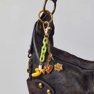 Retro-Schlüsselanhänger mit Bananen-, Herz- und Blumenanhängern an einer Ledertasche