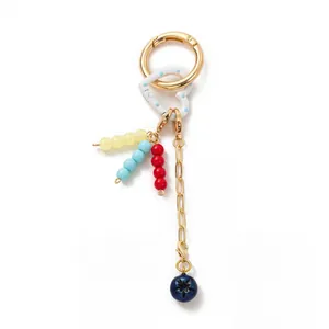 Detail of 18K gold-plated keychain with blue polka dot heart and colorful bead charms