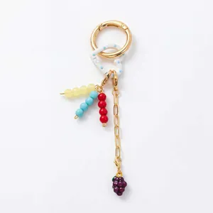 Detail of 18K gold plated keychain with colorful beads and a grape shaped charm