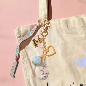 Porte-clés DIY avec breloques abeille cœur dauphin et ruban floral sur sac en toile