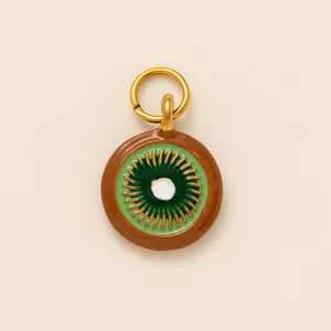 Macro shot of a 18K gold plated kiwi fruit slice pendant with green enamel detail