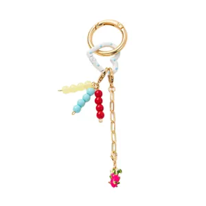 Golden keychain with heart resin piece, colorful beads and pink fruit pendant