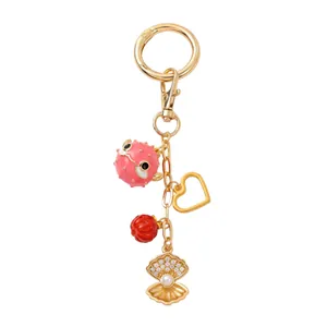 Détails du porte-clés mode avec fugu rose, cœur doré et pendentifs en forme de coquillage