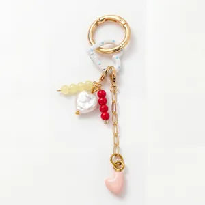 Detail of 18K gold plated keychain with blue polka dot heart, pearls, and colorful beads
