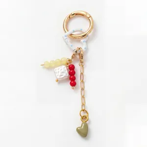 Detail of 18K gold plated keyring featuring heart pendant and colorful beads jewelry